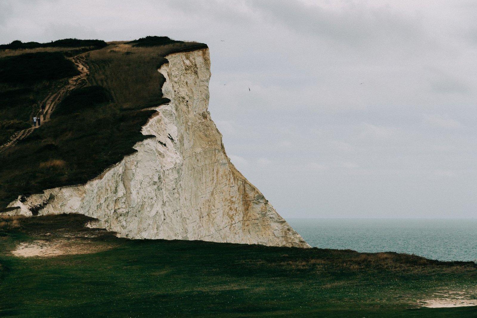 A person walking beside the Dover coast in daylight