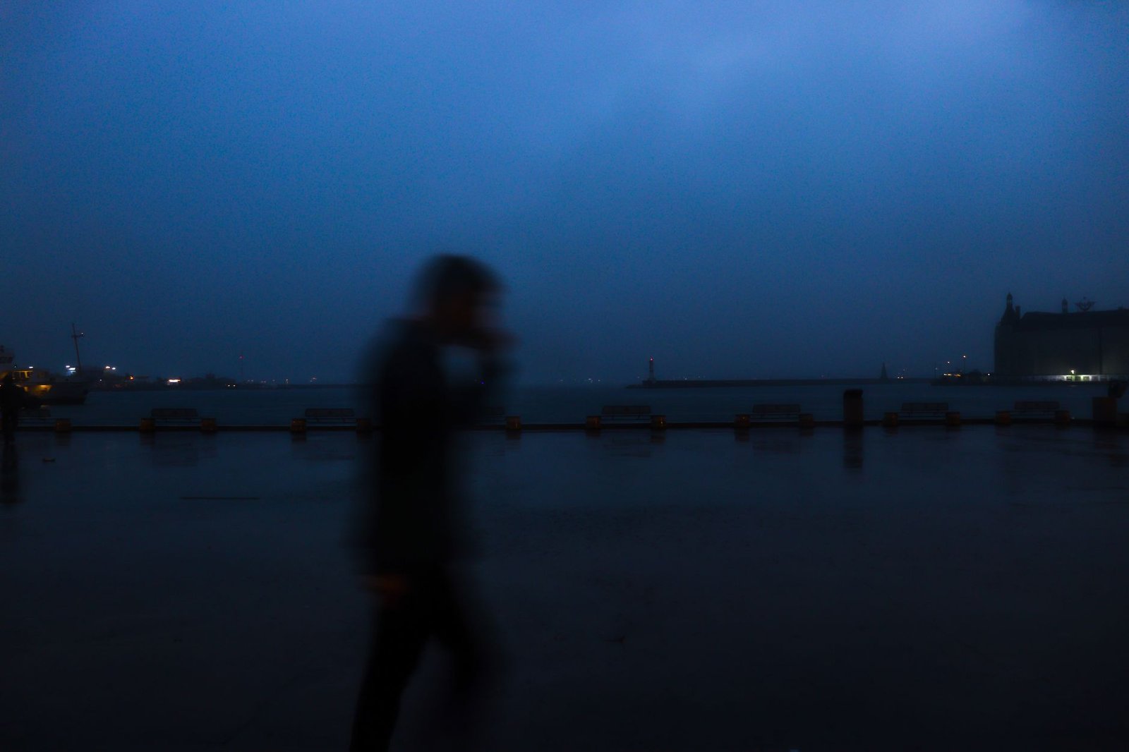 Adult man walking beside Hull waterfront in the evening