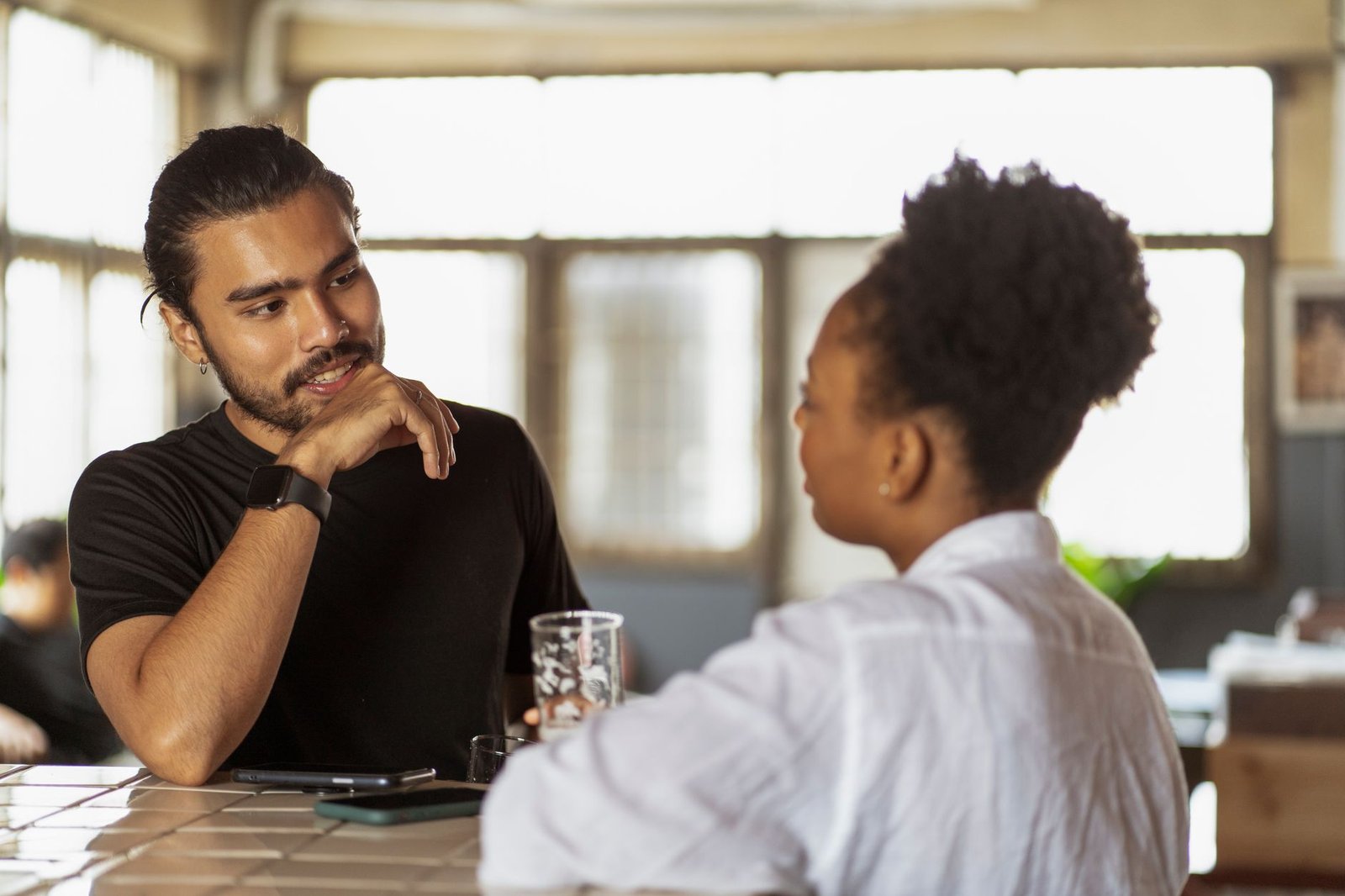 Two adults having a respectful conversation in a modern cafe