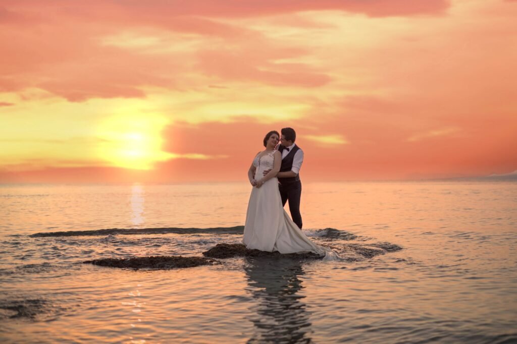 A couple embraces on a beach in Dubai during a breathtaking sunset, capturing their special wedding moment.