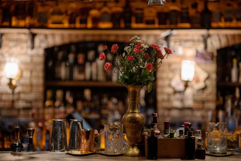 A golden vase with flowers adds elegance to a cozy bar interior.