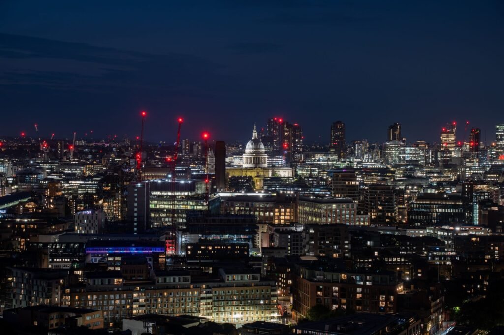 Beautiful nighttime view of London's skyline with St. Paul's Cathedral illuminated among city lights.