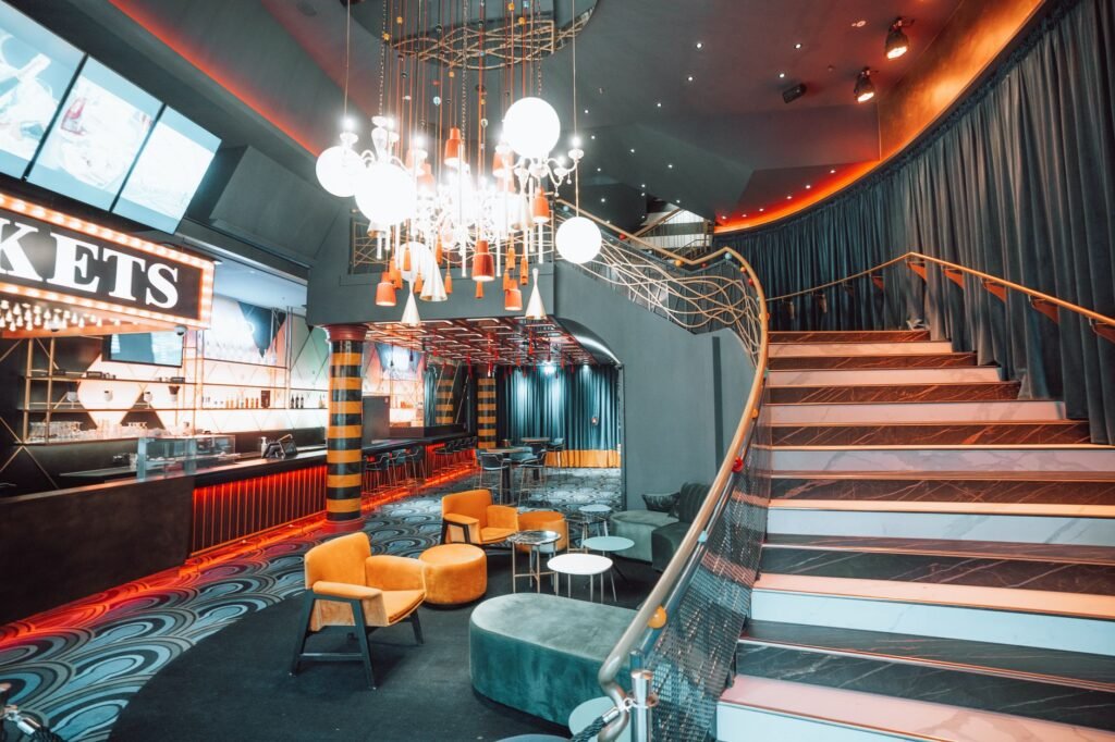 Luxurious bar interior featuring a grand staircase, modern lighting, and stylish seating for a sophisticated ambiance.