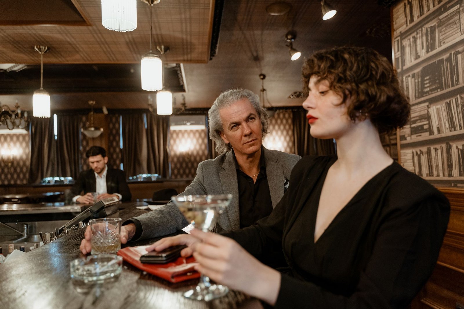 Sophisticated couple enjoying cocktails in a luxurious bar setting, capturing a moment of connection.