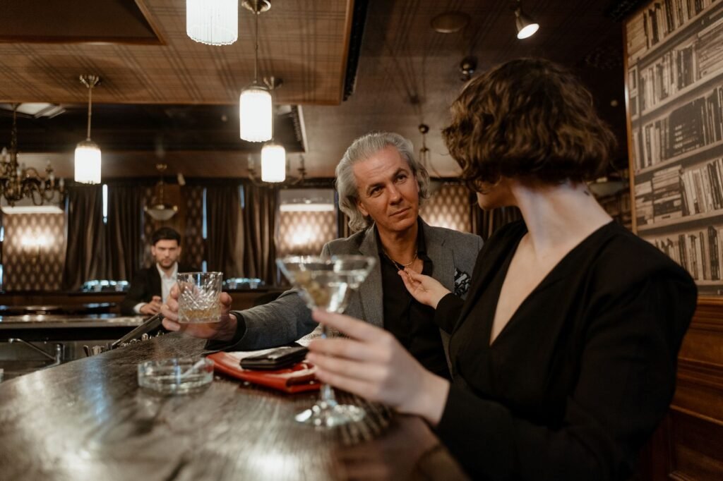 Sophisticated adults enjoying drinks in a vintage-style bar ambiance.