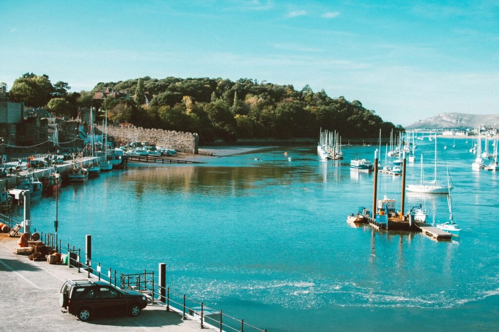 Serene view of Conwy Marina with boats and clear blue sky in Wales.