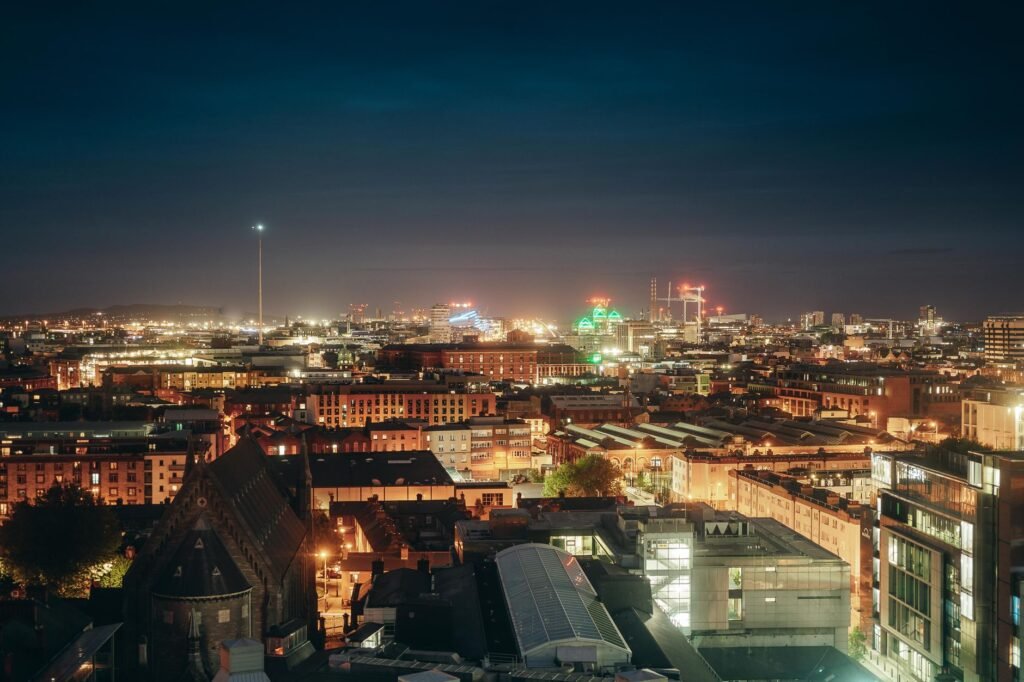 A stunning aerial view of Dublin's illuminated skyline at night, showcasing vibrant city lights and architecture.