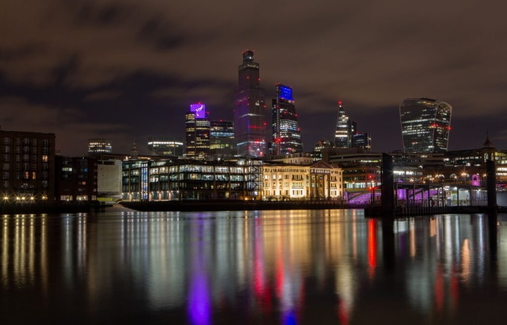 Captivating night cityscape of London's skyline reflected in the Thames River.