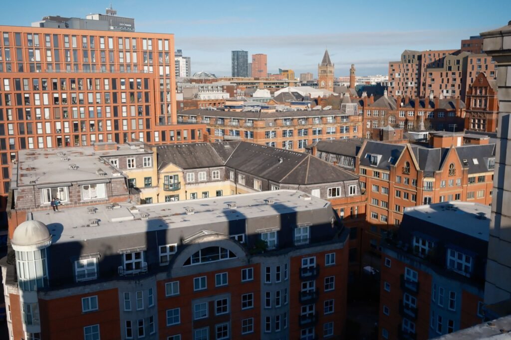 View of Manchester skyline showcasing distinctive red brick buildings under blue skies.
