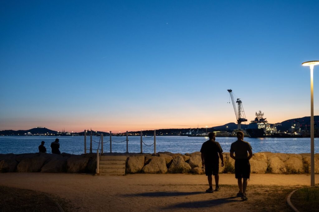 Adults taking an evening stroll along a seaside promenade