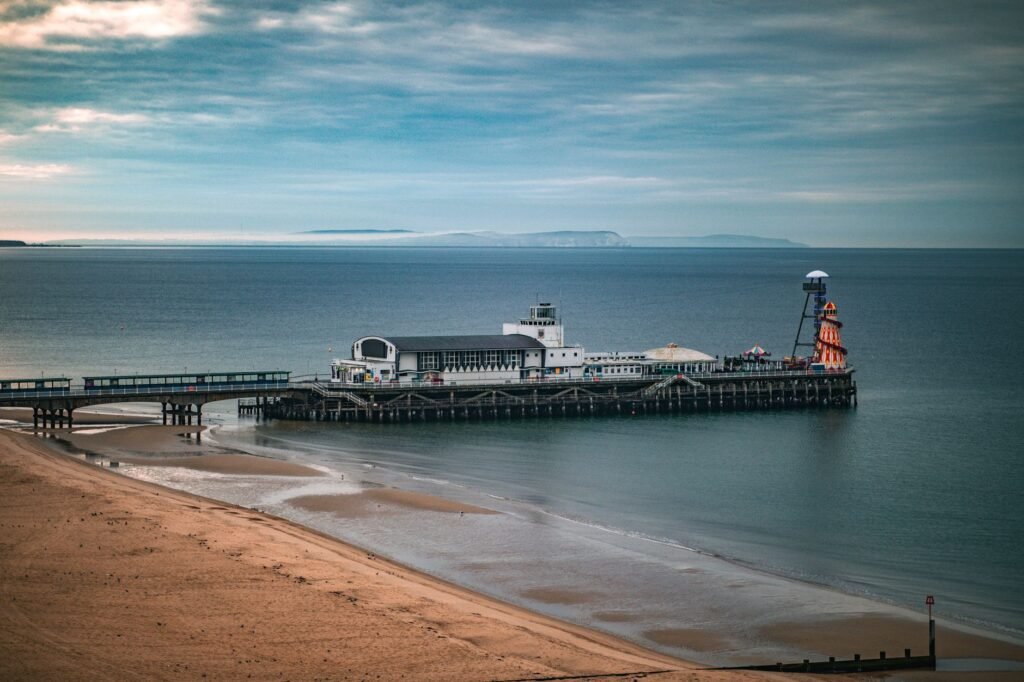 A tranquil scene of Bournemouth Pier extending into the calm sea under a colorful sky, showcasing the serene English coastlin