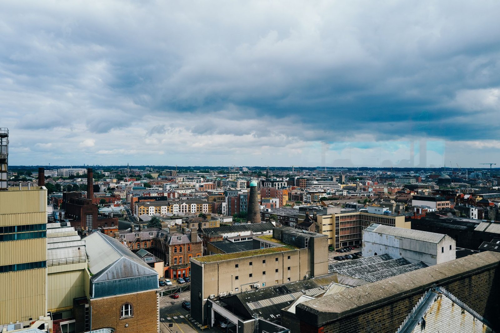 Aerial view of a bustling city with overcast skies, showcasing urban architecture.