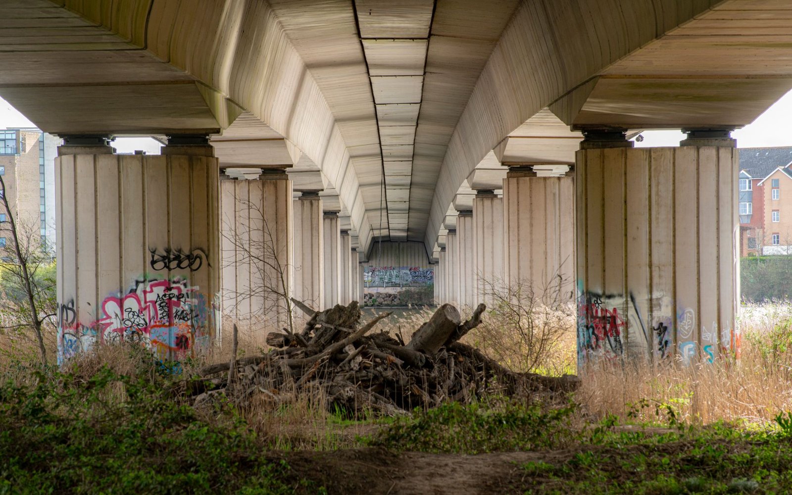 Dynamic view under Cardiff bridge showcasing urban graffiti and architectural design.