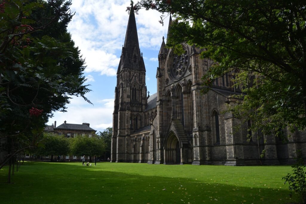 Beautiful Gothic cathedral surrounded by lush greenery in Edinburgh, Scotland.