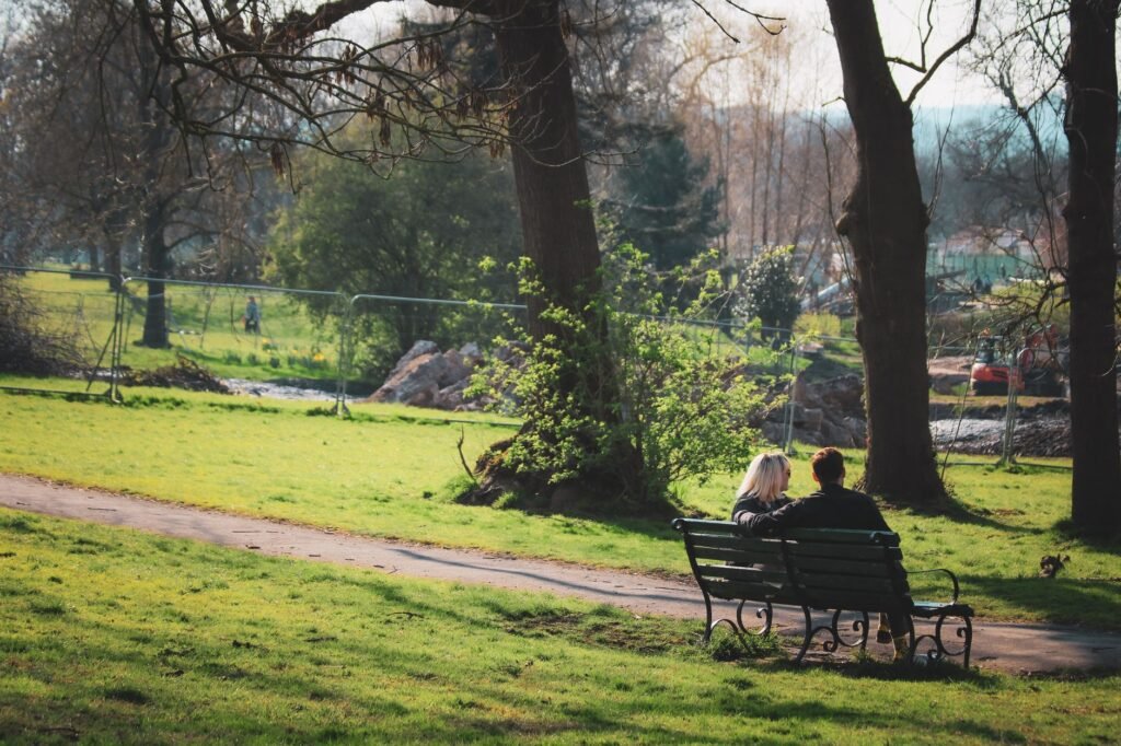 A couple enjoys a peaceful moment on a park bench in Bristol, England.