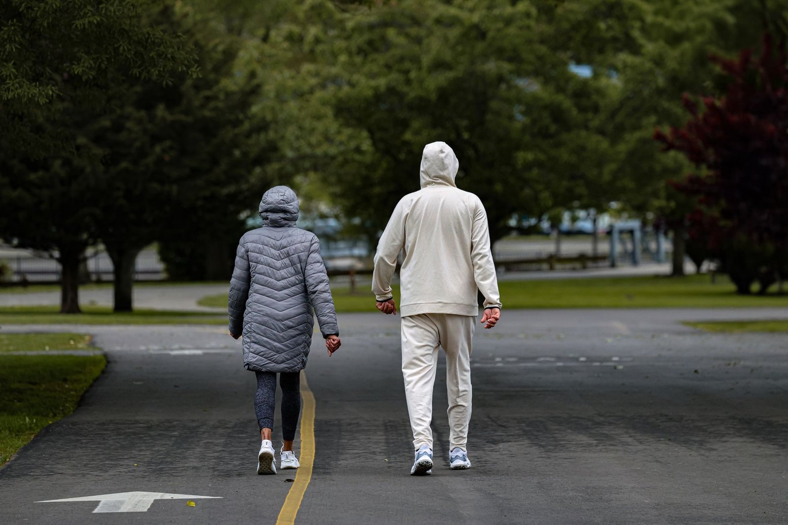 A couple enjoying a stroll at Cove Island Park in Stamford, Connecticut, surrounded by lush greenery.