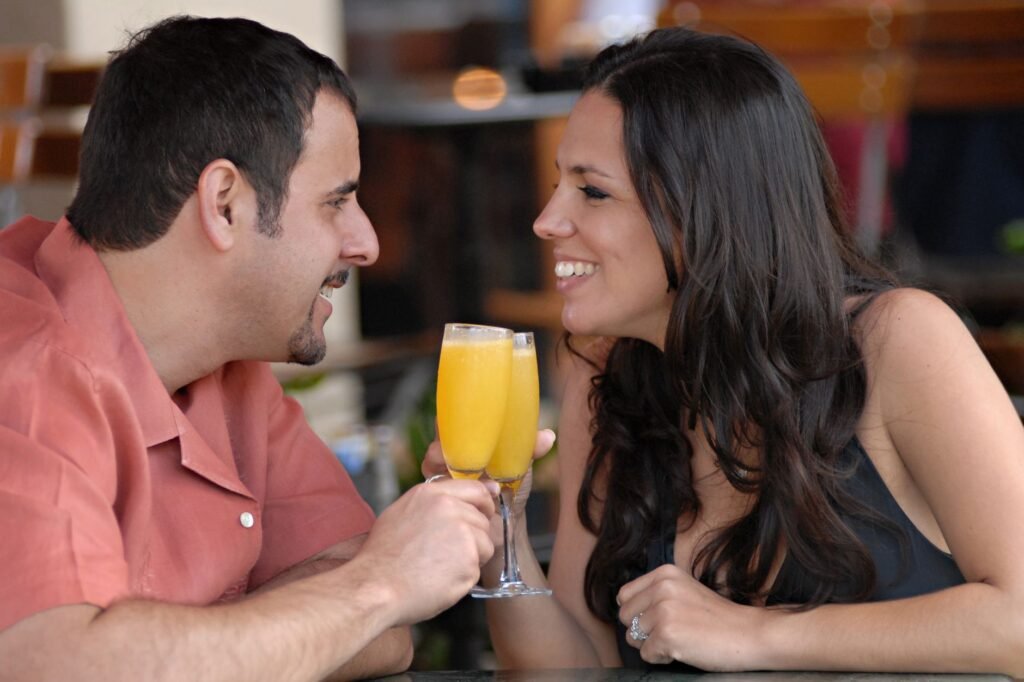Smiling couple enjoying mimosas at a Miami Beach café. Perfect for lifestyle and travel themes.