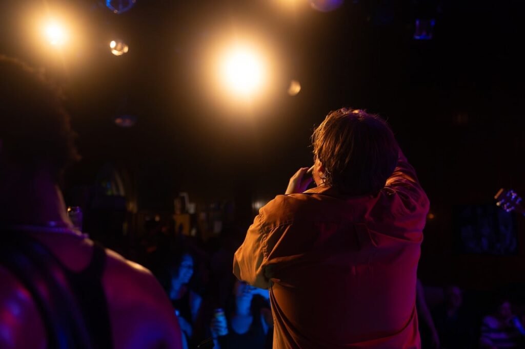 concert, singer, audience, stage, spotlight, orange, show, room, live music, entertainment, fans, atmosphere, music, micropho