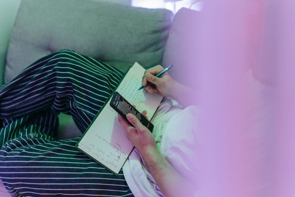 Person reviewing booking details on a smartphone beside handwritten notes