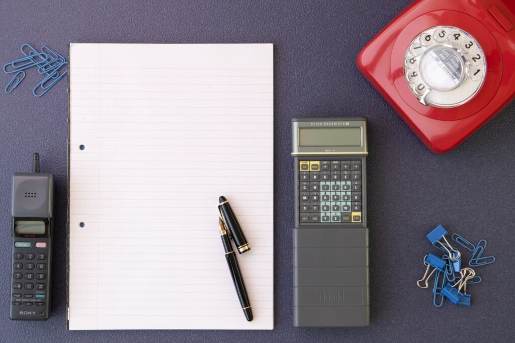 Writing down clear booking details beside a smartphone