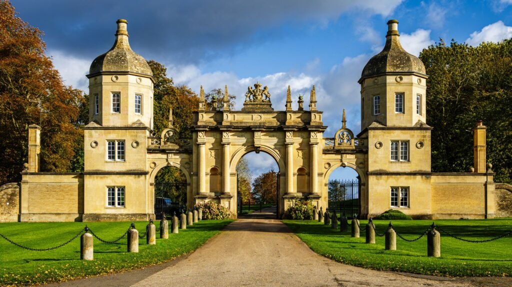 Grand entrance gate in Peterborough surrounded by lush greenery.