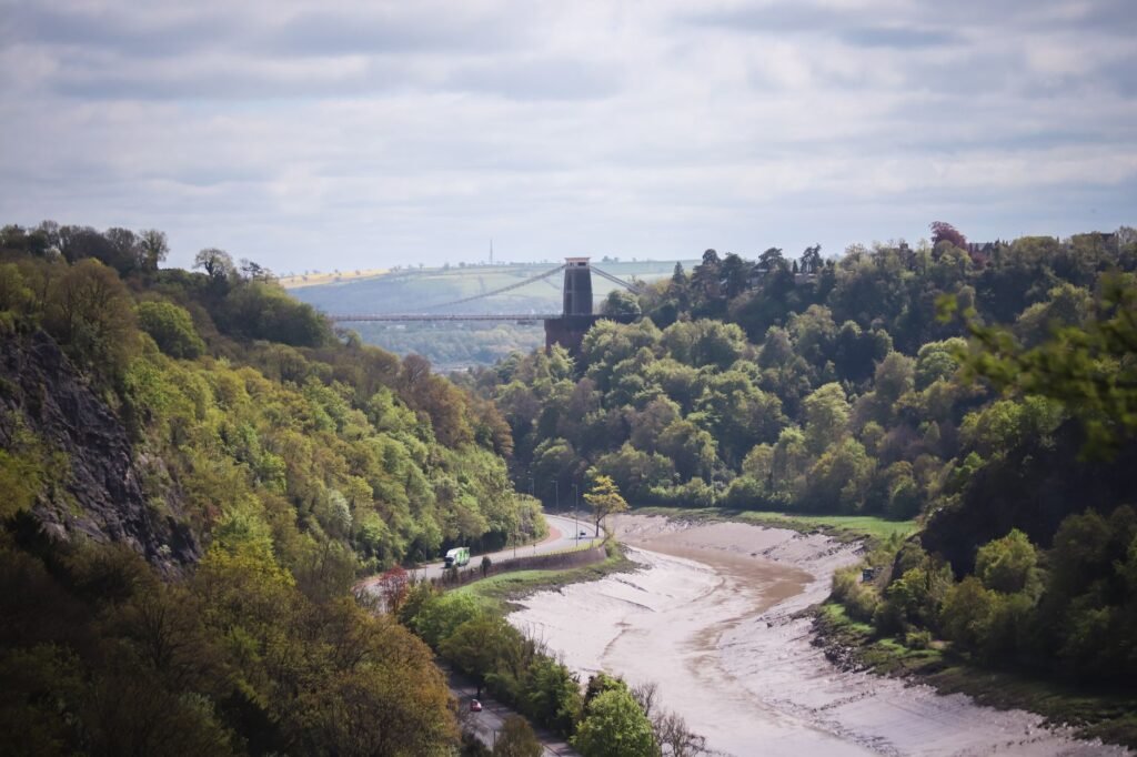 A scenic view of the Clifton Suspension Bridge spanning the Avon Gorge in Bristol, England.
