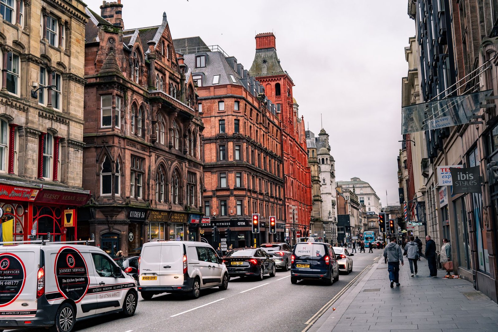 Busy street with historic buildings and traffic in a lively city center.