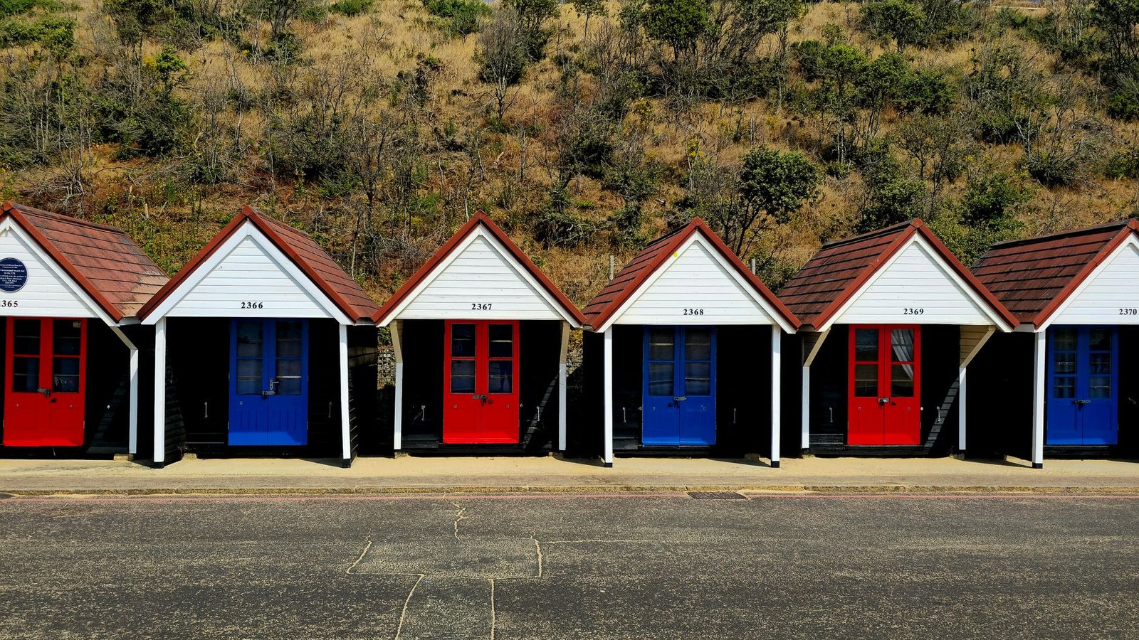 Vibrant beach huts line the coast in Bournemouth, England, offering a picturesque seaside view.