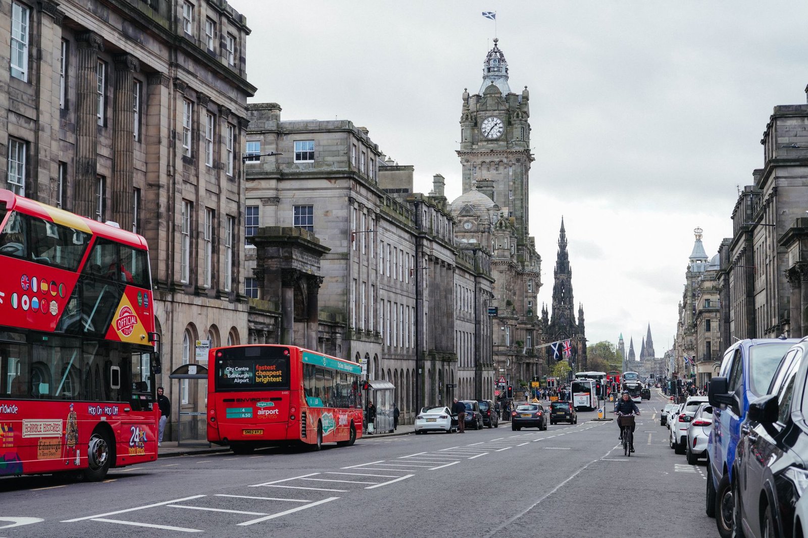 View of Edinburgh's Princes Street with the iconic Balmoral Hotel and bustling city traffic in Scotland.