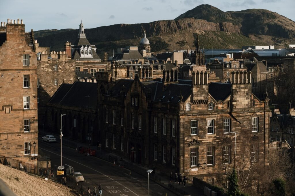 View of historic Edinburgh streets and buildings with Arthur's Seat in the background.