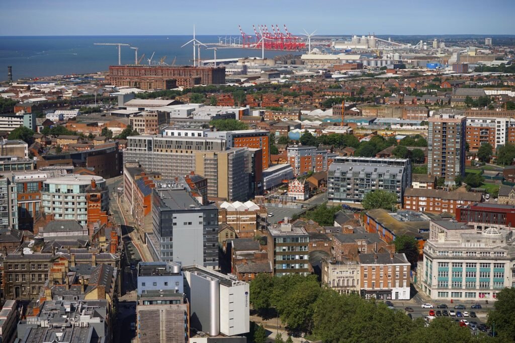Aerial view of Liverpool cityscape showcasing buildings and docks under a clear sky.