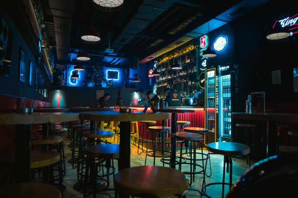 Trendy bar interior with neon lights and empty seats, perfect for nightlife themes.