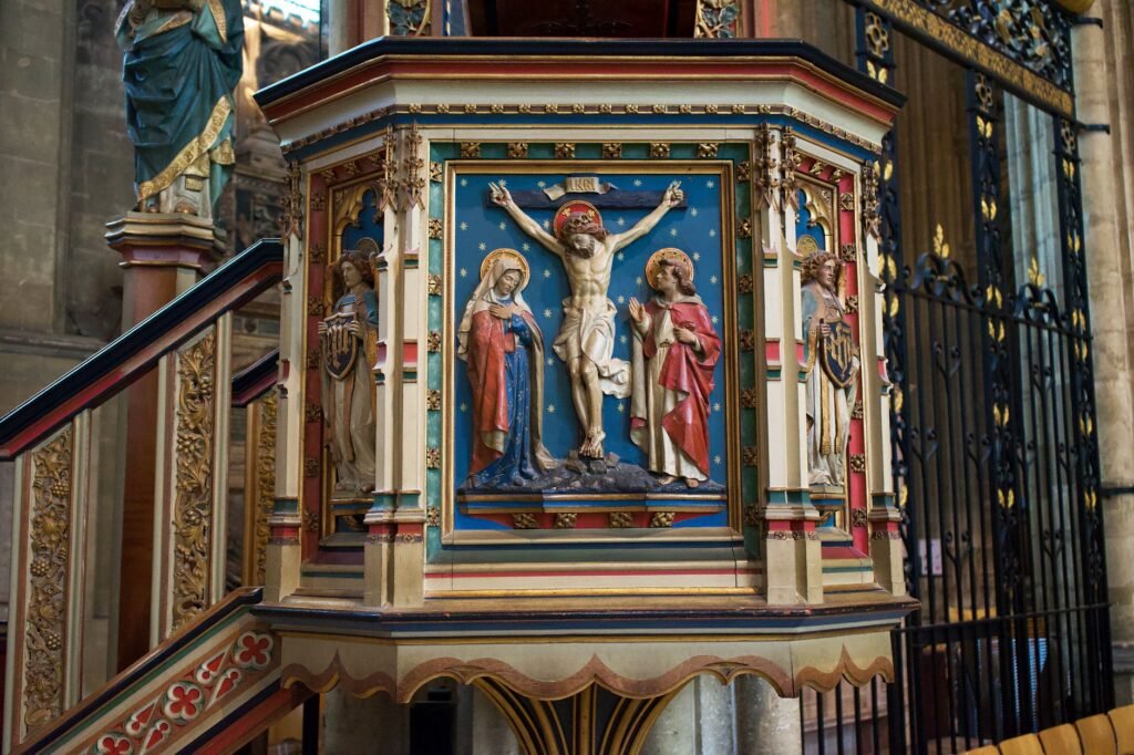 Detailed view of ornate religious carvings on the pulpit inside Canterbury Cathedral, England.