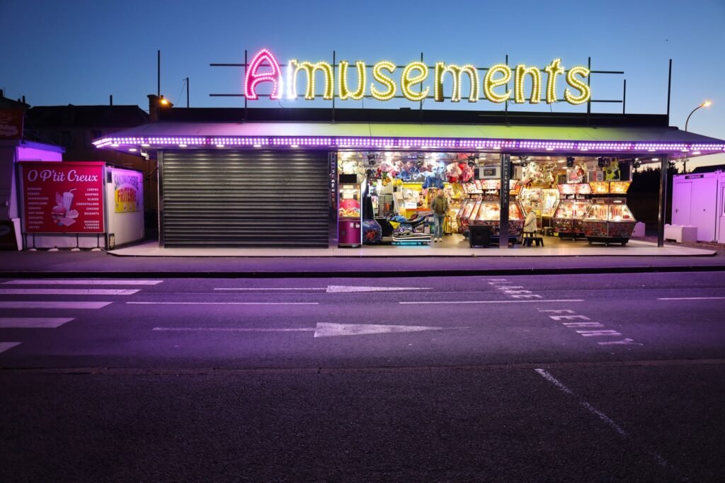 Colorful amusement arcade with neon lights in Ouistreham, Normandy, France, captured at night.