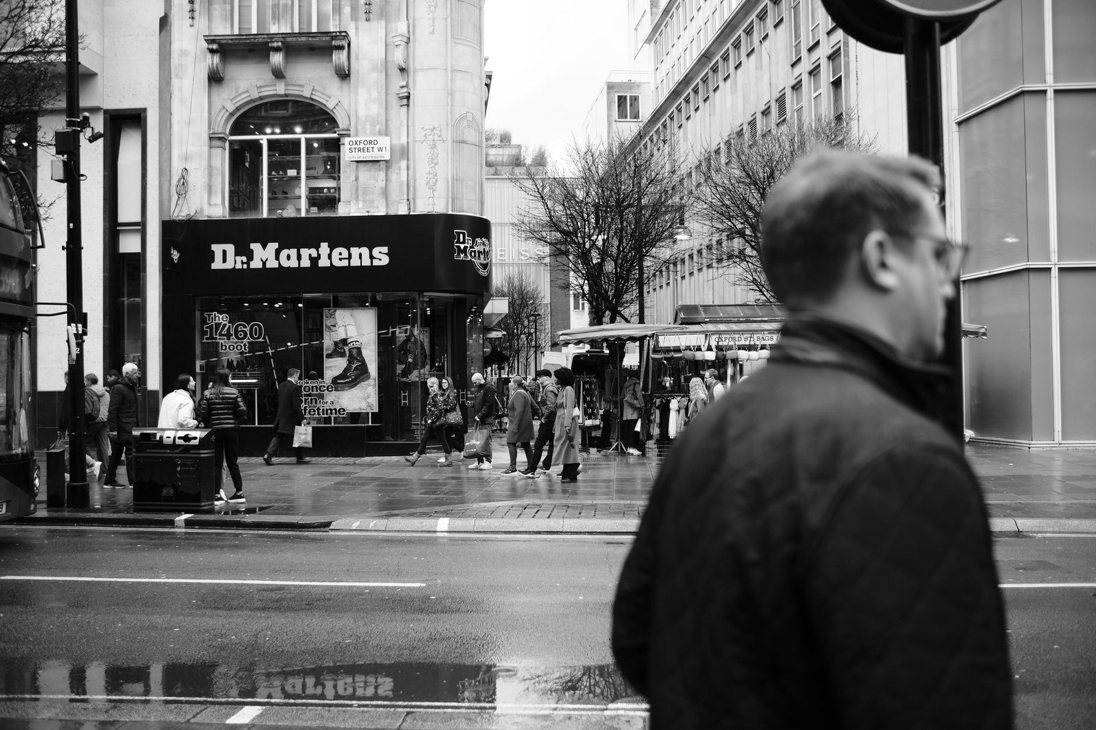 Monochrome view of bustling Oxford Street in London featuring pedestrians and a Dr. Martens store.