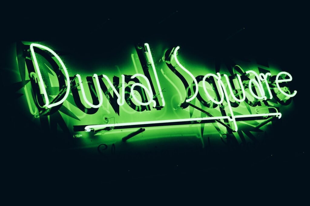 Glowing green neon sign with 'Duval Square' showcasing nightlife in Key West.