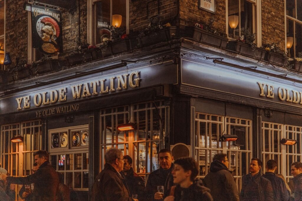 Nighttime scene at Ye Olde Watling Pub in London, capturing city life and local culture.