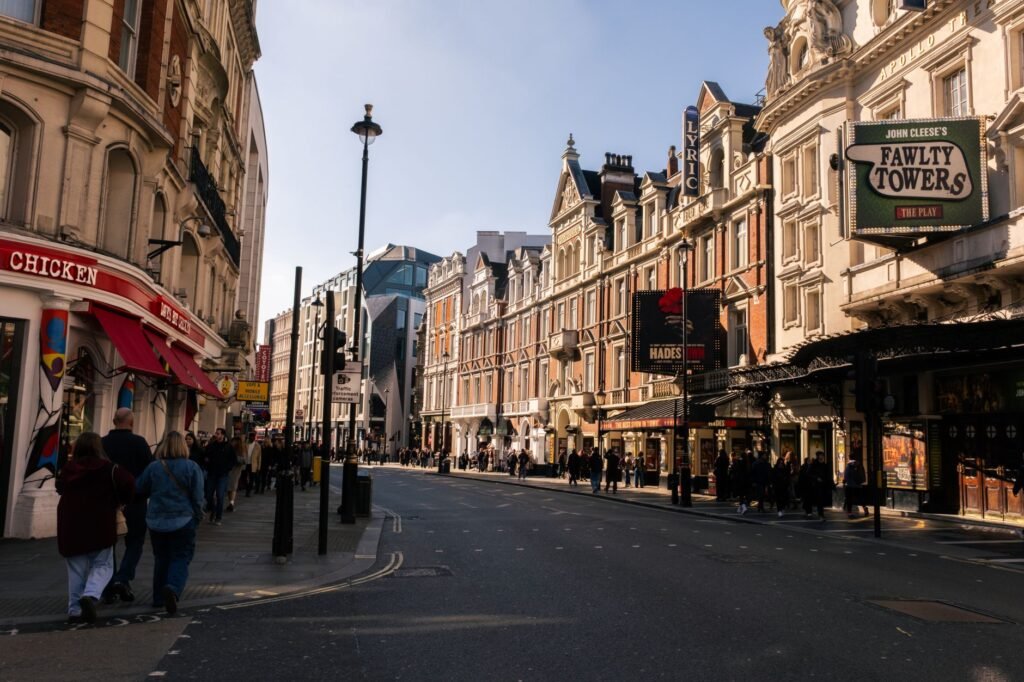Bustling street in London featuring historic theatres and vibrant city life.