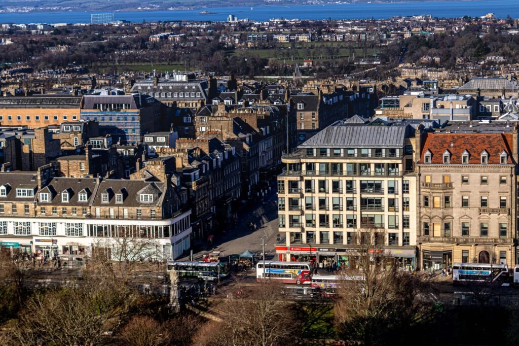 Aerial view of Edinburgh displaying historic buildings and vibrant street life on a clear day.