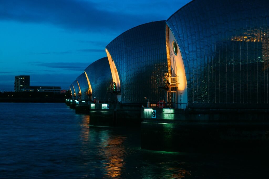 A vibrant evening shot of the Thames Barrier in London, highlighting modern architecture and warm lighting.