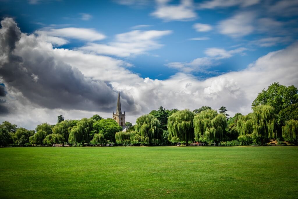 Beautiful landscape of St. Mary's Church surrounded by lush greenery and blue skies in Stratford-upon-Avon.