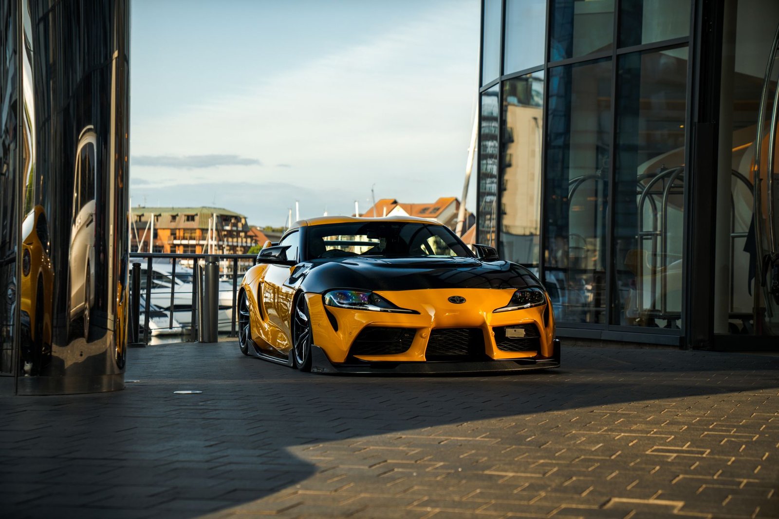 Yellow and black sports car parked indoors with a marina view in Southampton, England.