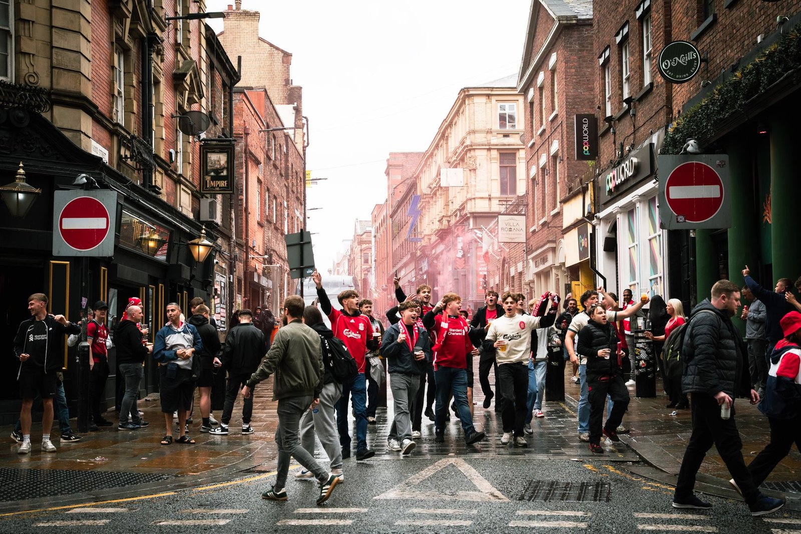 A vibrant street scene of football fans celebrating in Liverpool, England.