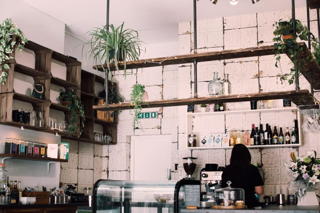 Charming rustic café interior with lush plants and a barista at work, featuring a vintage vibe.