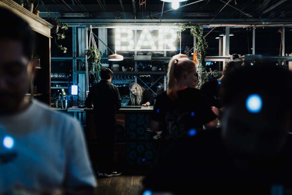 A lively indoor bar scene with illuminated decor and patrons enjoying a night out.