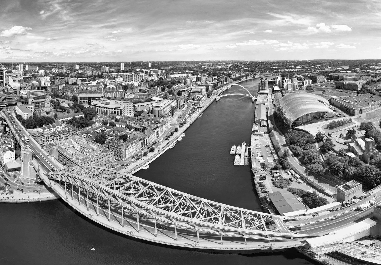 Black and white aerial view of Tyne Bridge and Quayside in Newcastle upon Tyne, highlighting architectural beauty.