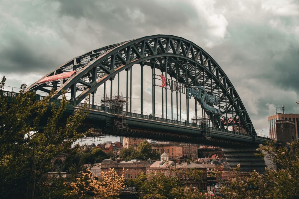 View of the historic Tyne Bridge in Newcastle upon Tyne, England amidst a cloudy sky.