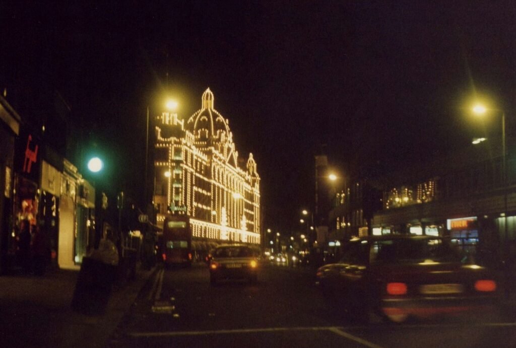 Captivating nighttime street scene showcasing an illuminated city building with bustling traffic.
