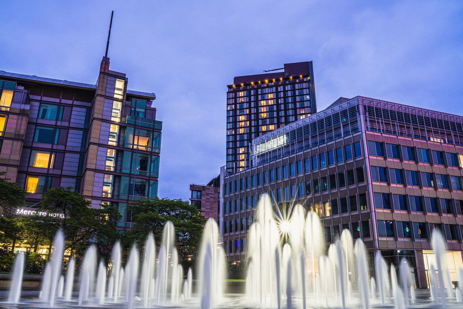 Night view of Sheffield city center with modern buildings and illuminated fountains capturing urban beauty.