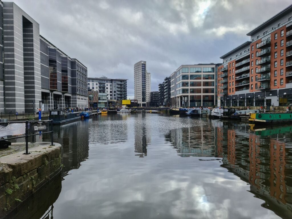 View of contemporary buildings along the canal in Leeds, England under cloudy skies.